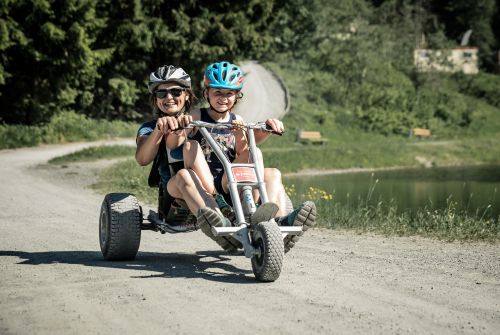 Vrouw met kind dat een mountaincart bestuurt - Regio St. Johann in Tirol