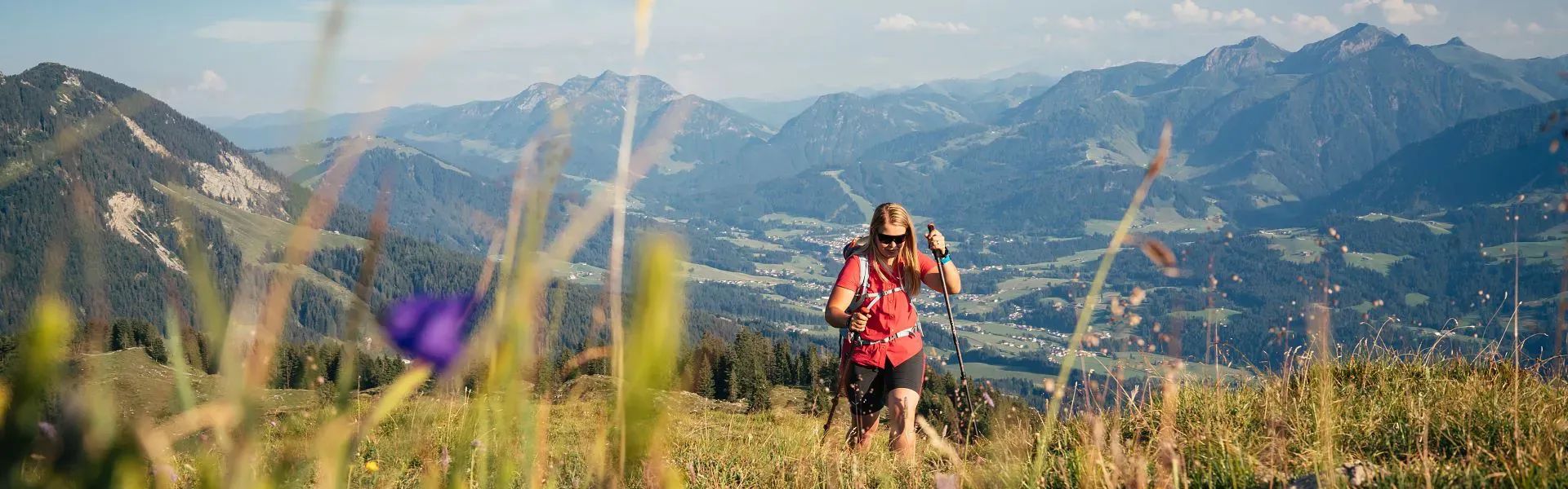 Kitzbüheler Alpen Hero Wandern Christina Foidl am Weg zum Gipfel des Baumooskogels im Hintergrund die Region St.Johann c Daniel Gollner