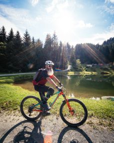 Kitzbühel Alps bike hero Marco Brandstätter with a mountain bike in front of the reservoir on the Harschbichl trail in St.Johann Tirol c Daniel Gollner