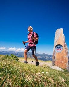 Kitzbühel-Alps-Hero-Hiking-Elke-Henke-hiking-past-the-KAT-Walk-stone-on-the-Lodronalm-in-Kelchsau-c-Daniel-Gollner