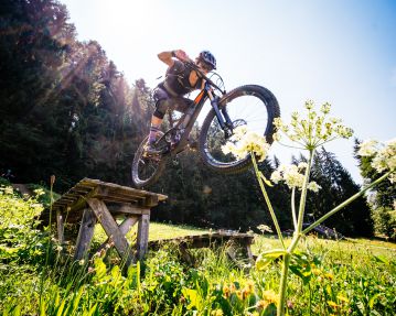 Kitzbühel Alps Hero Bike Lena Koller jumping across a drop in Brixental Valley with her mountain bike c Daniel Gollner