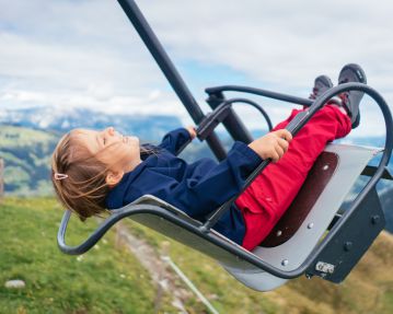 Kitzbüheler Alpen Hero Familie O´Brien Mädchen hat Spaß beim Schaukeln im Alpinolino in Westendorf c Daniel Gollner