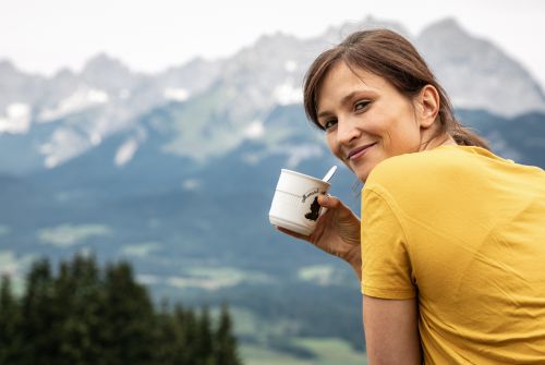 Vrouw met een kopje op alpenweide - Regio St. Johann in Tirol