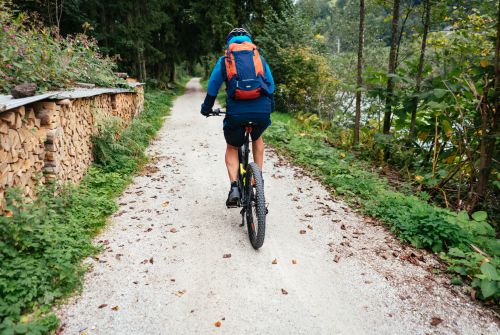 Kitzbühel Alps bike hero Patrick Ager riding along a gravel path alongside the Ache towards Wörgl c Daniel Gollner